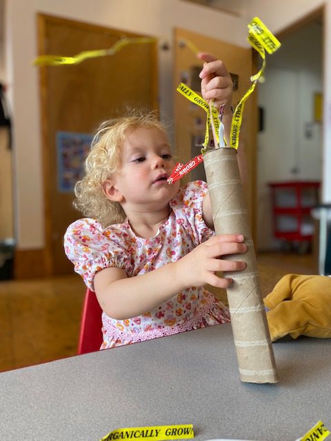 Child stuffing things in a tube